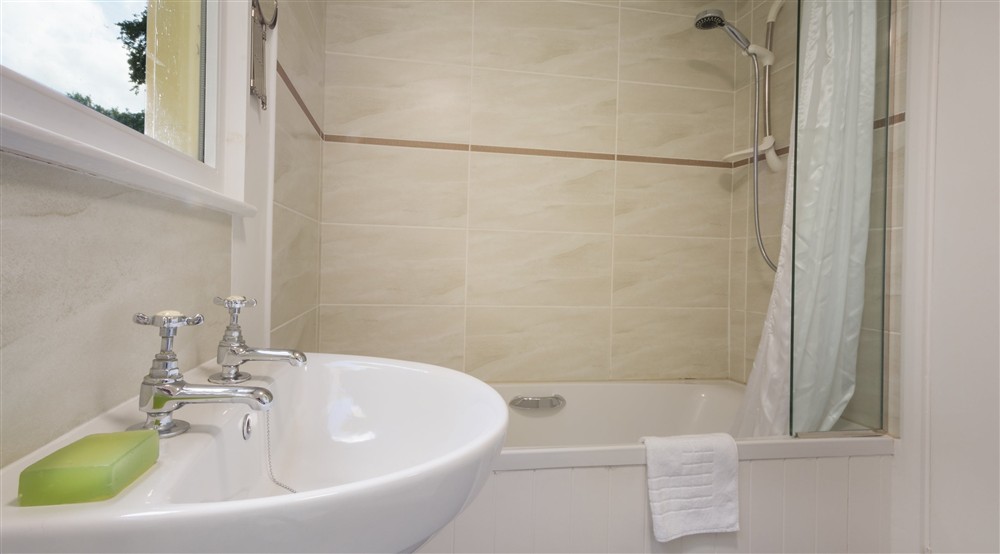 The bathroom with shower over bath at Warcleave Cottage in Newton Abbot, Devon
