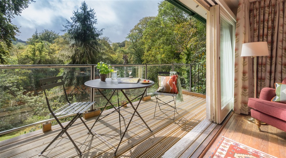 The dining table and chairs for two on the balcony at Warcleave Cottage in Newton Abbot, Devon