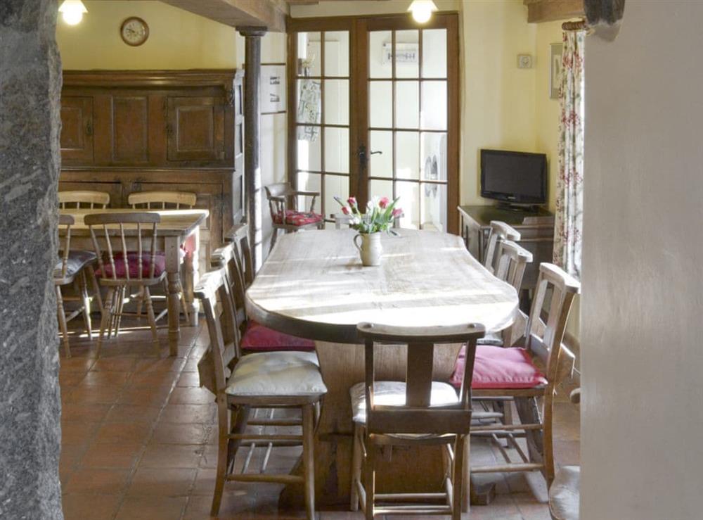 Convenient dining area within kitchen with useful utility room beyond at Warmhill Farmhouse in Newton Abbot, Devon