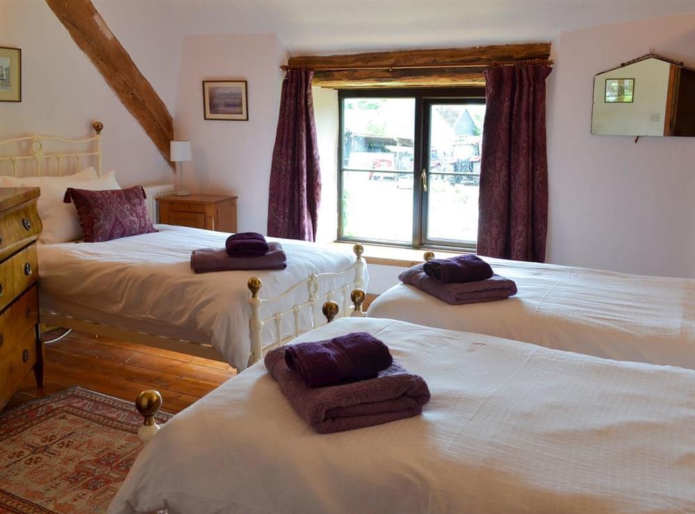 Large triple bedroom with three single beds at Warmhill Farmhouse in Newton Abbot, Devon