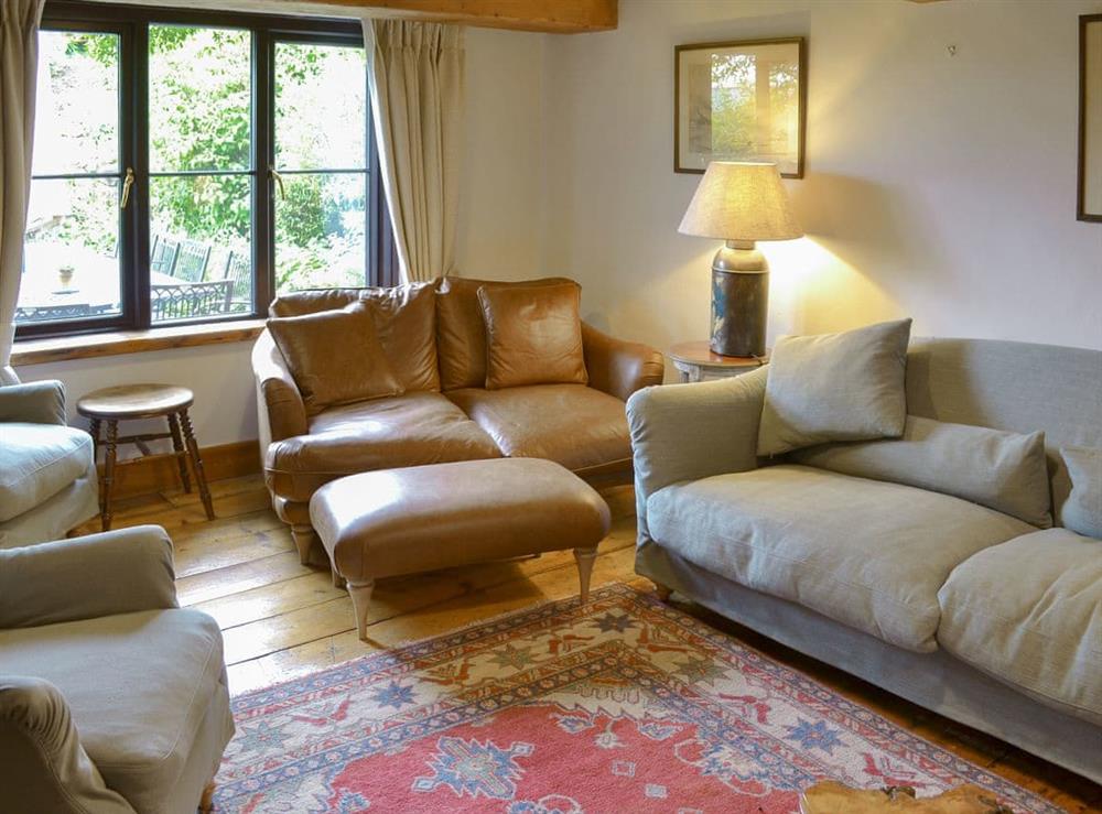 Spacious living room with characterful exposed wooden beams at Warmhill Farmhouse in Newton Abbot, Devon