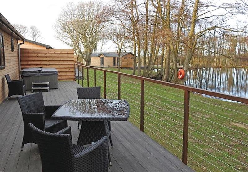 The terrace with a hot tub in a Selby Superior Lake View at Warren Wood Country Park in Hailsham, East Sussex