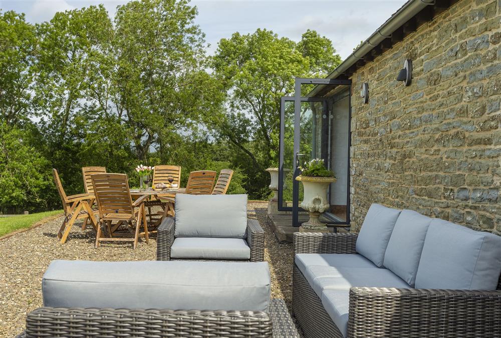 Outdoor seating area with wooden table and chair set and additional rattan garden furniture (photo 2) at Wassell Barn, Craven Arms