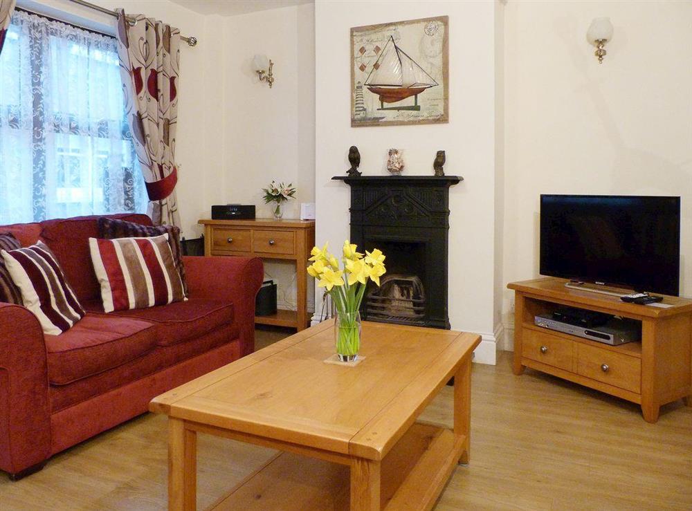 Cosy living room with open fireplace at Watchkeepers Cottage in Mundesley, Norfolk