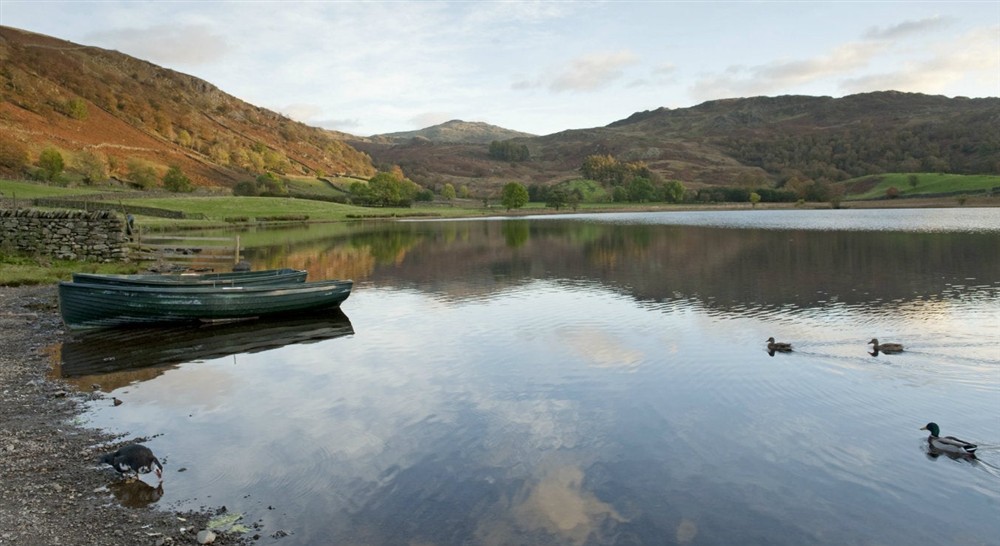 Boats and ducks on Watendlath Tarn, Lake District at Watendlath Bothy in Keswick, Cumbria