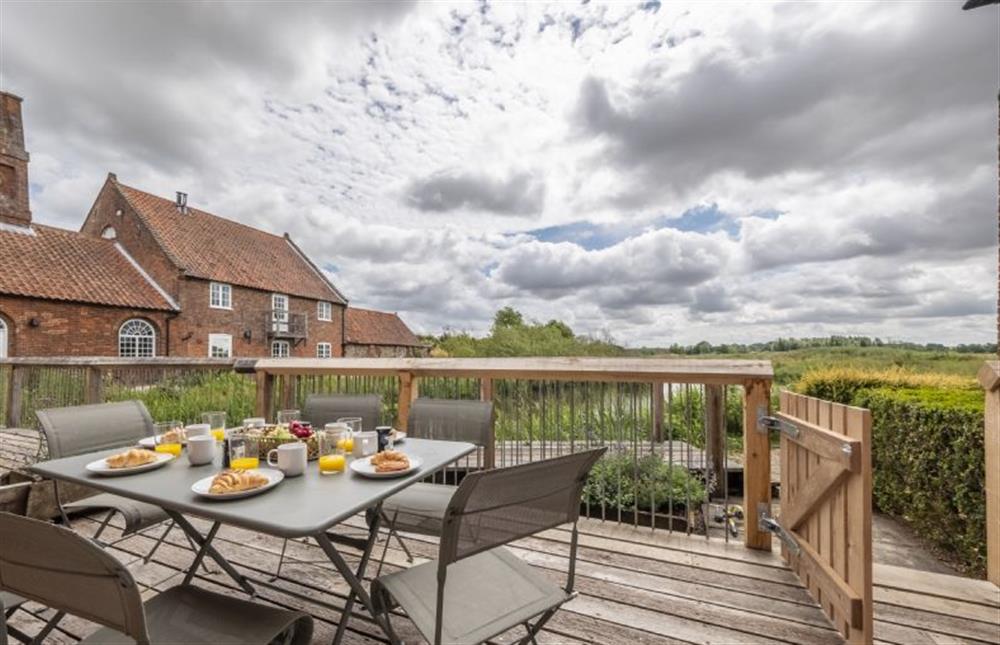 Enjoy the idyllic views from the deck at Water Mill House, Burnham Overy Staithe near Kings Lynn