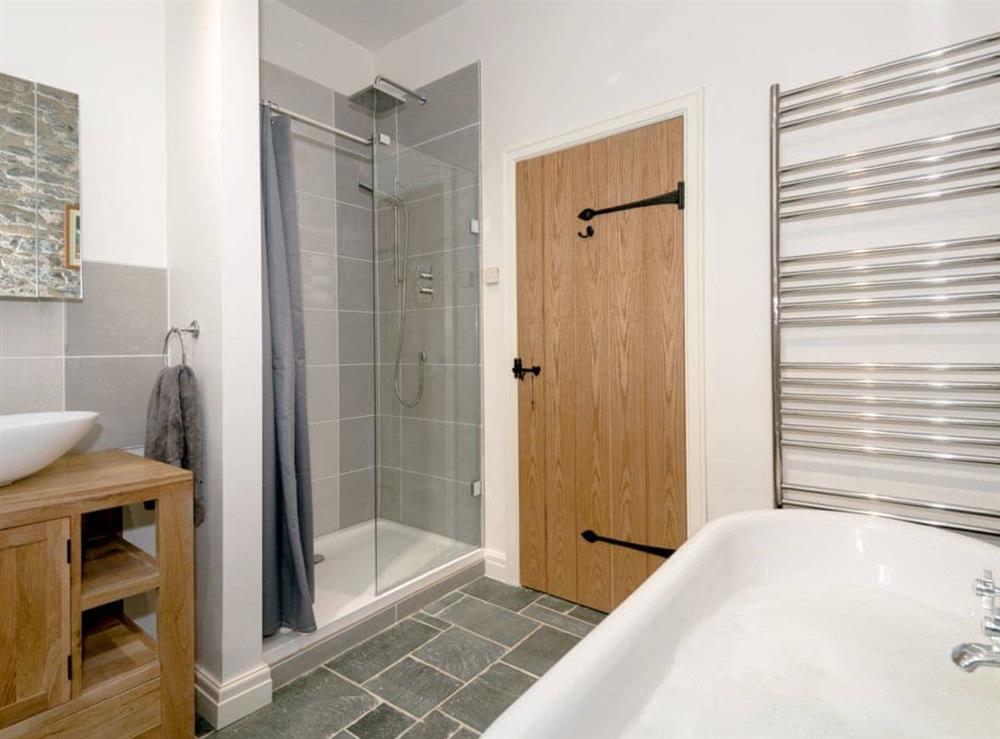 Bathroom with roll-top bath, shower cubicle and toilet at Waterfall Wood Cottage in Glenridding, near Keswick, Cumbria