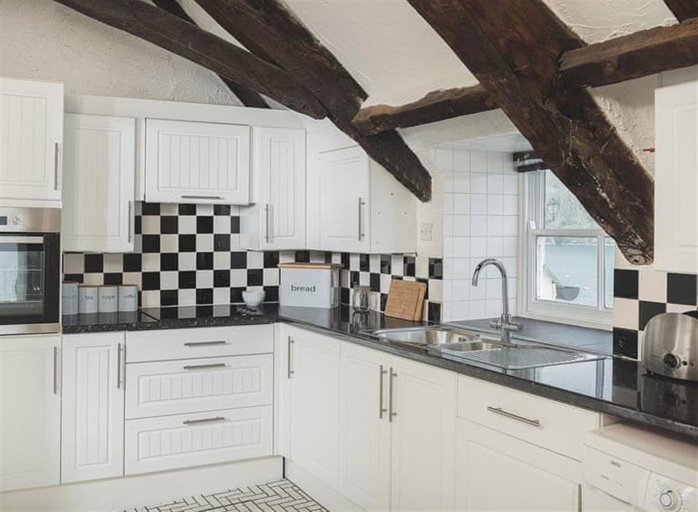 The modern fitted kitchen has built in appliances at Waterfront Apartment in Fowey, Cornwall