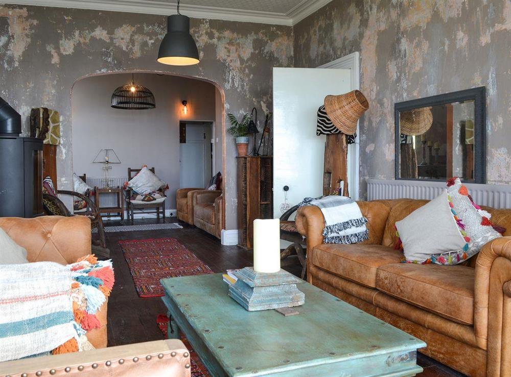 Living room with wood flooring & wood burner at Waterfront Beach House in Criccieth, near Porthmadog, Gwynedd