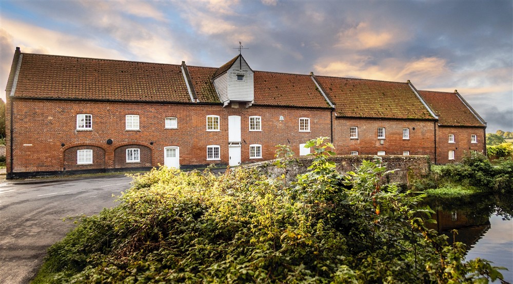 The exterior of the former watermill that houses Millstream and the neighbouring apartments, overlooking the mill pool, Norfolk at Watermill Apartment in Burnham-overy-staithe, Norfolk