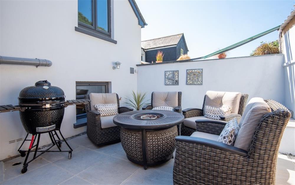 Stunning rear terrace with rocking chairs and a feature gas fire with kamado joe barbecue! at Waters Edge in Beesands