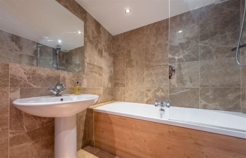 Bathroom with bath with overhead shower at Waterside Barn, Binham near Fakenham