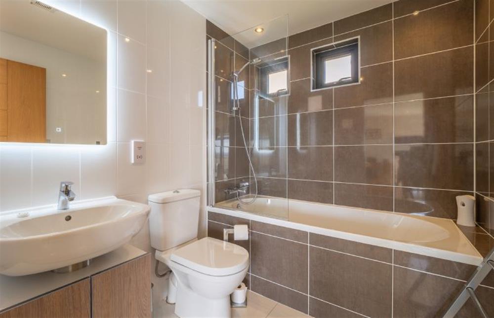 Family bathroom with shower over bath, wash basin and WC at Wavelength, Chapel Porth, St Agnes