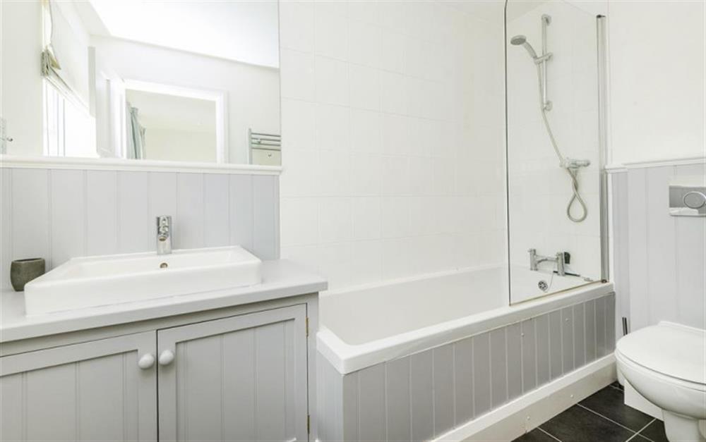 En suite bathroom with bath, shower over, WC, basin & heated towel rail at Wayfarings in Thurlestone