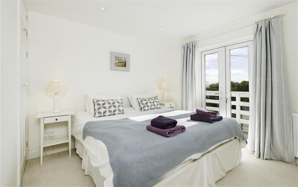 The master bedroom,  opening onto the balcony, with sea views at Wayfarings in Thurlestone
