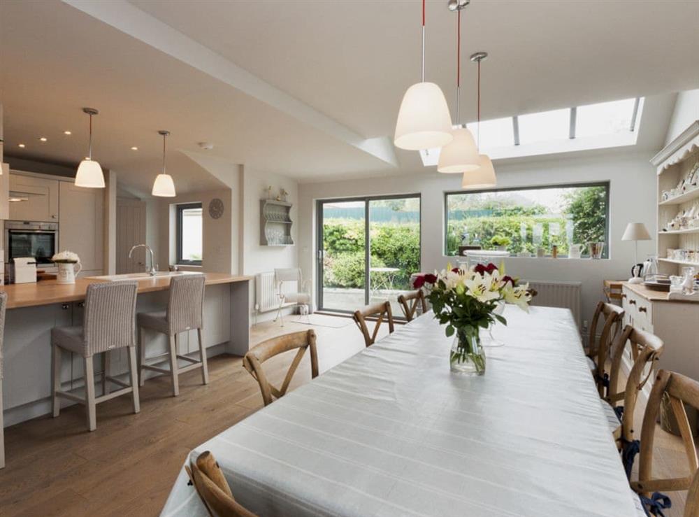 Large dining area and contemporary kitchen with sliding doors to patio at Weald in Salcombe, Devon