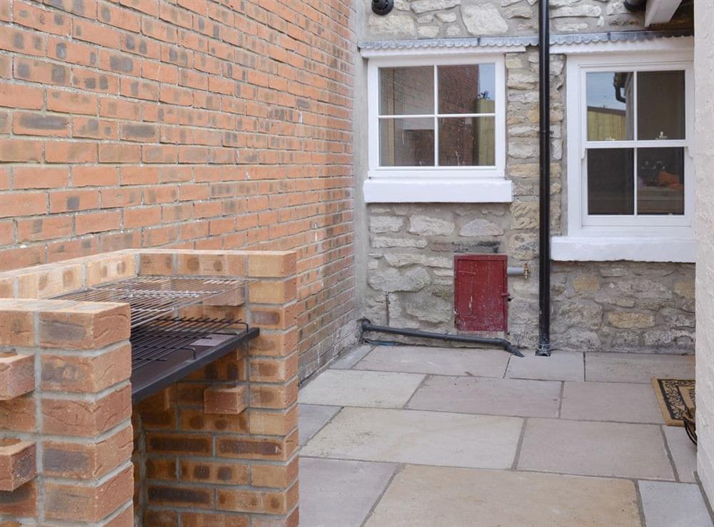Rear courtyard with built-in BBQ at Weavers Cottage in Pickering, North Yorkshire