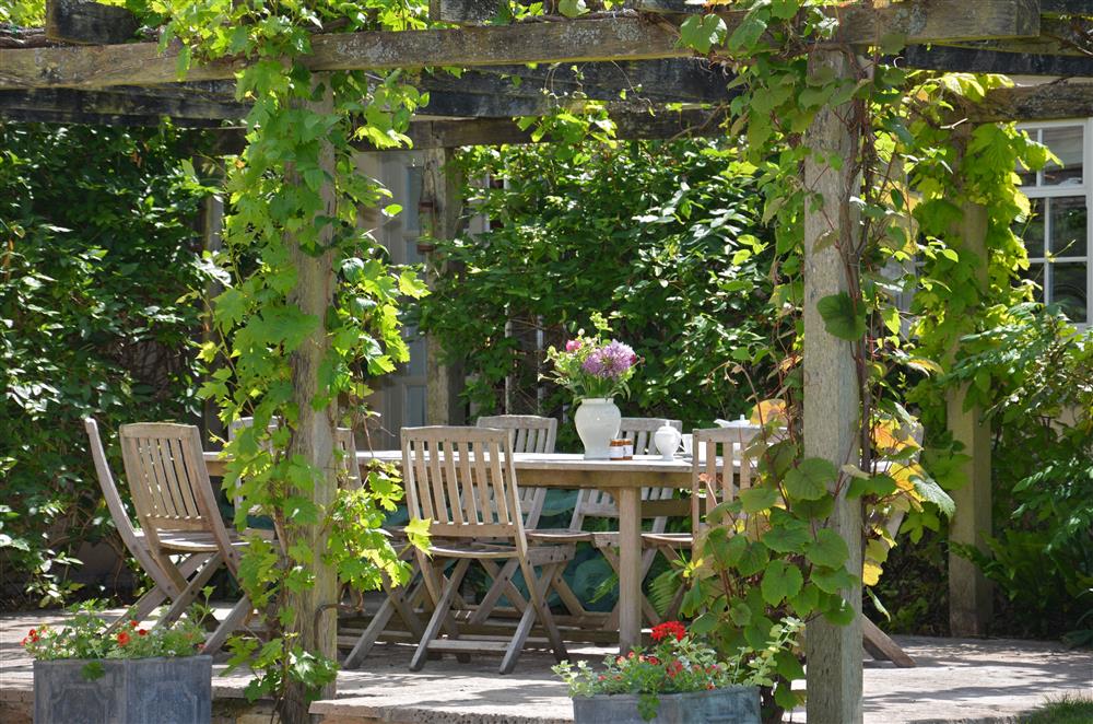 Enjoy alfresco dining on the front patio, accessed via bedroom five or the sitting room at Weir House, Bruern, near Chipping Norton