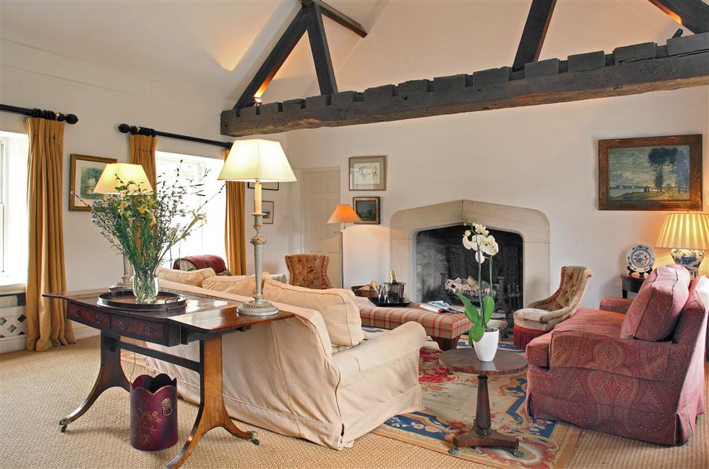 The sitting room boasts beautiful exposed beams and a Gothic style stone open-fire
