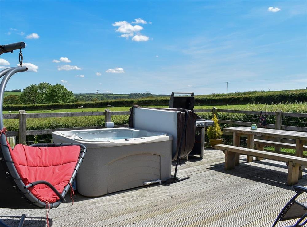 Large decked area with garden furniture and gas barbecue at Rivendell Glamping Pod, 