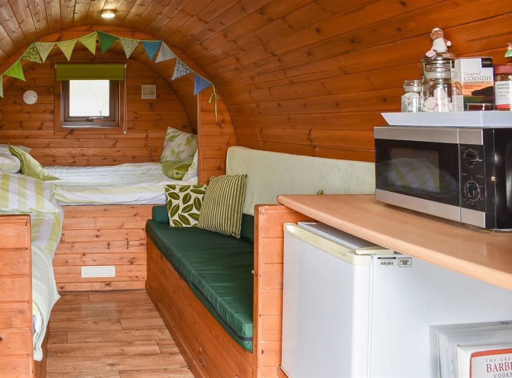 Small, yet oerfectly formed living space with single and double beds at Rivendell Glamping Pod, 