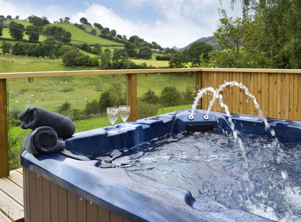 Relax and enjoy the idyllic setting from the luxurious hot tub at Wern Ddu Cottage in Penybontfawr, near Oswestry, Powys
