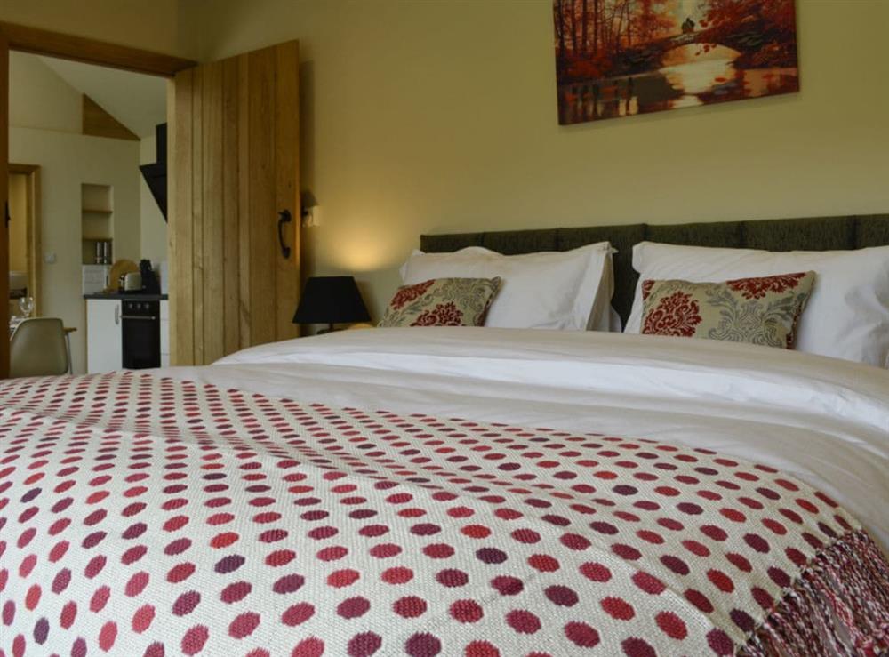 Stylish bedroom with zip and link king-size bed and en-suite at Wern Ddu Cottage in Penybontfawr, near Oswestry, Powys