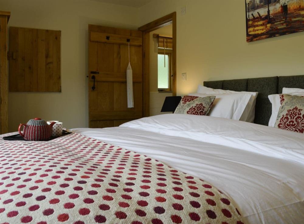 Tastefully furnished bedroom with zip and link king-size bed and en-suite at Wern Ddu Cottage in Penybontfawr, near Oswestry, Powys