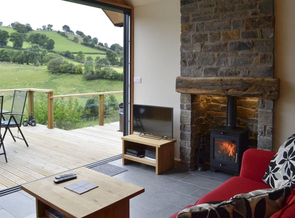 Welcoming lounge with Freeview TV and wood burner at Wern Ddu Cottage in Penybontfawr, near Oswestry, Powys