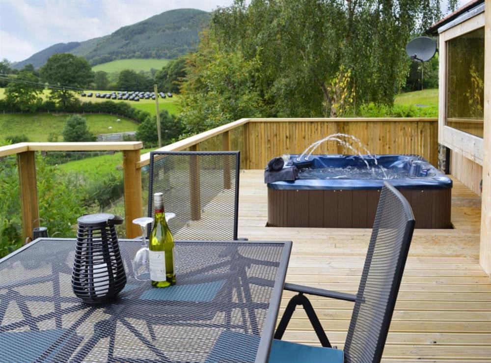 Wonderful decked terrace with hot tub and patio furniture at Wern Ddu Cottage in Penybontfawr, near Oswestry, Powys