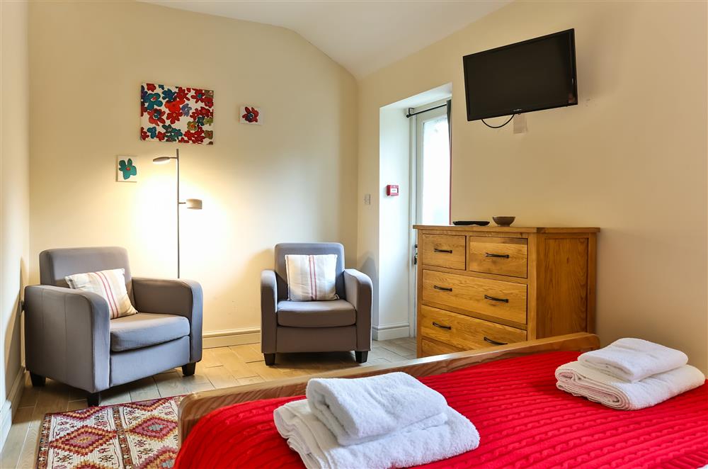 Brushing Rooms bedroom with comfortable seating and a television with DVD player at Wern Manor and Cottages, Porthmadog