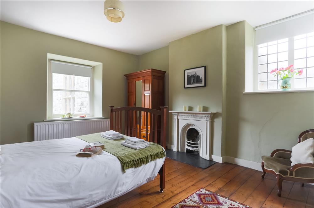 Stylish bedroom one with an ornamental fireplace at Wern Manor and Cottages, Porthmadog