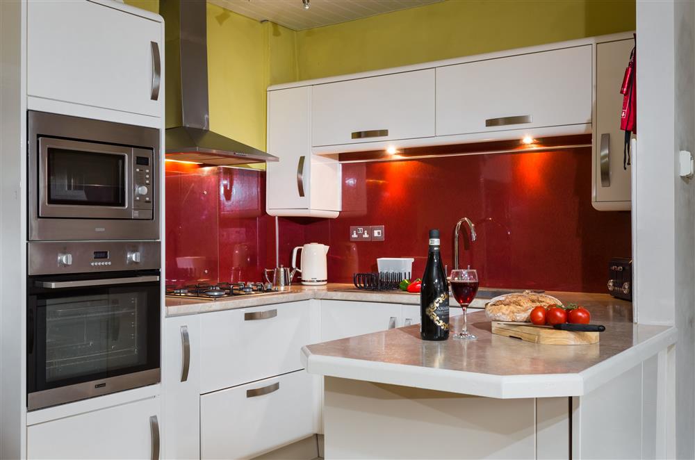 Well-equipped kitchen with an electric oven and gas hob at Wern Manor and Cottages, Porthmadog