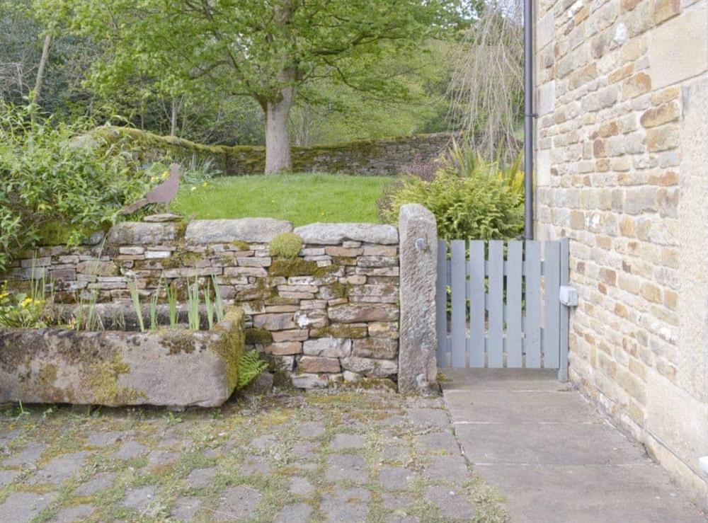 Enclosed patio leading to garden area at West Barn in Holymoorside, near Chesterfield, Derbyshire