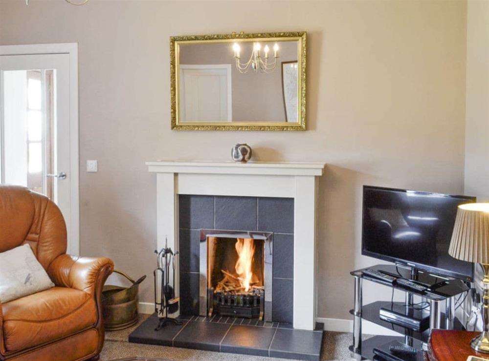 Inviting living room with an open fire at West Barr Cottage, 
