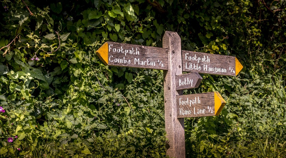 A sign for footpaths near West Challacombe Manor and Cottage, Devon at West Challacombe Manor in West Exmoor, Devon