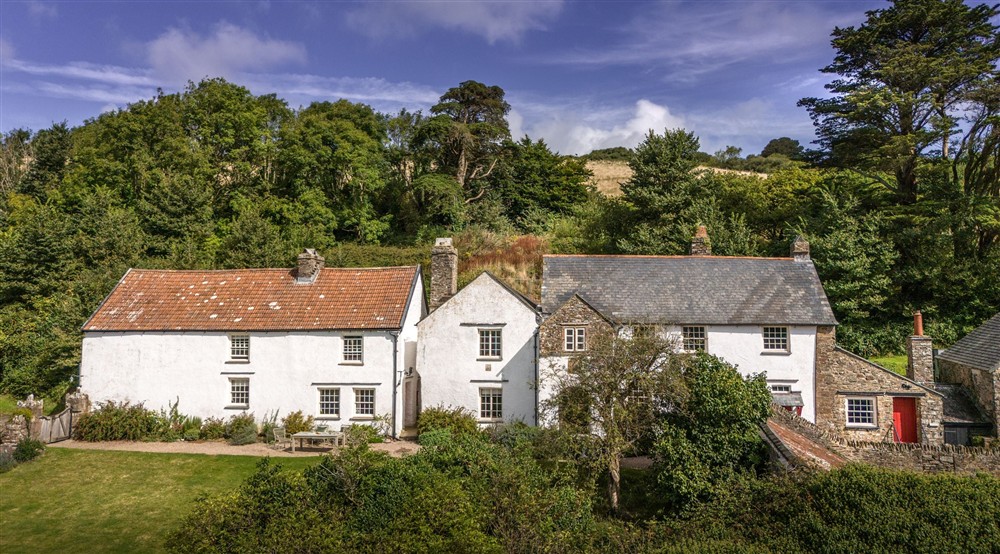 An aerial view of West Challacombe Manor on the right and neighbouring West Challacombe Cottage on the left, Devon at West Challacombe Manor in West Exmoor, Devon