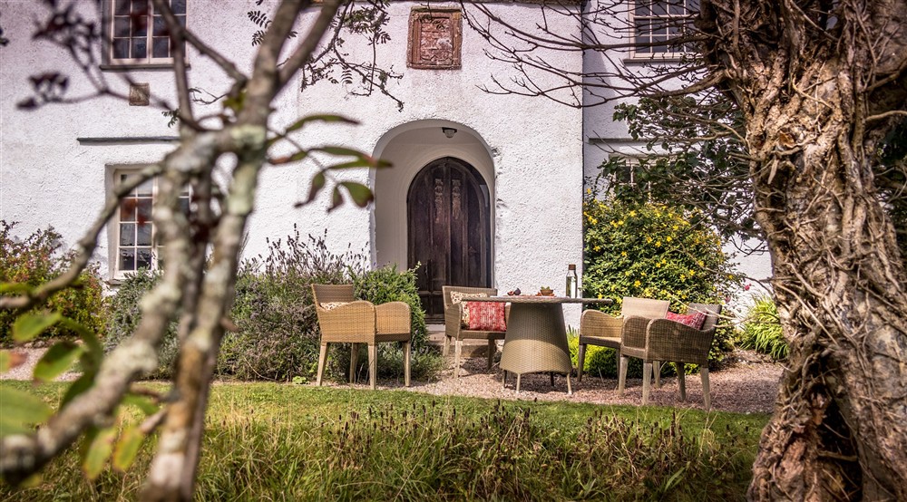 The front garden with outdoor dining furniture at West Challacombe Manor in West Exmoor, Devon