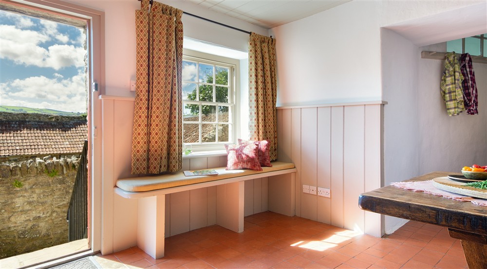 The main door, with bench seating next to it, in the dining room at West Challacombe Manor in West Exmoor, Devon