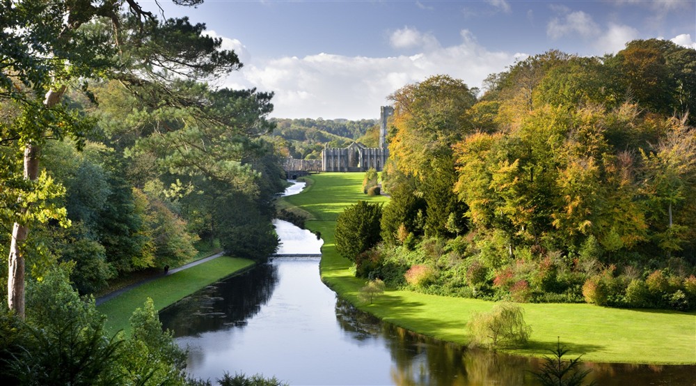 Looking over the Half Moon Pond and weir of Studley Royal Water Garden from the Surprise View towards Fountains Abbey, North Yorkshire. at West Gate Lodge in Ripon, North Yorkshire