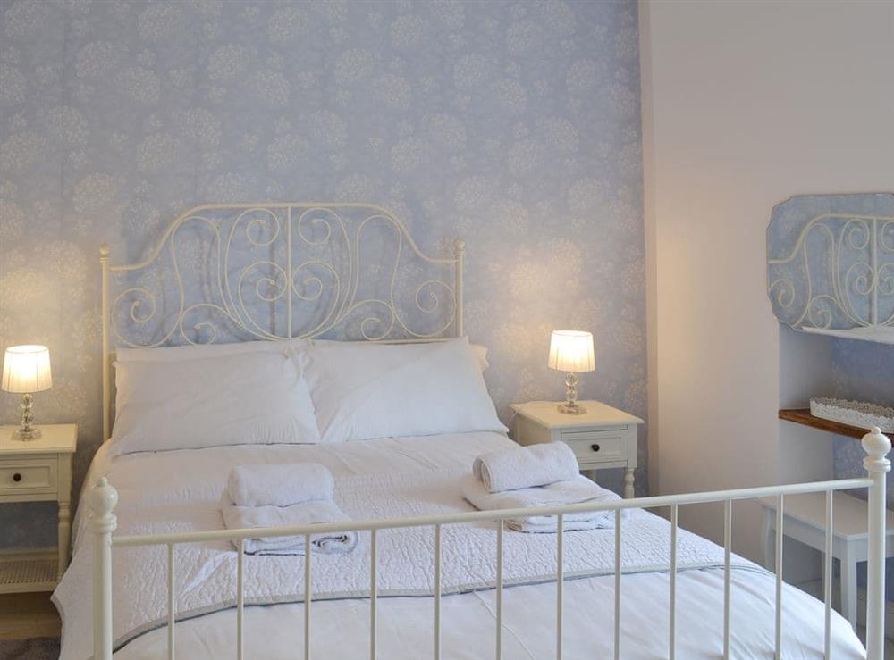 Romantic bedroom with antique style double bed at West House Farm in Muston, near Filey, North Yorkshire
