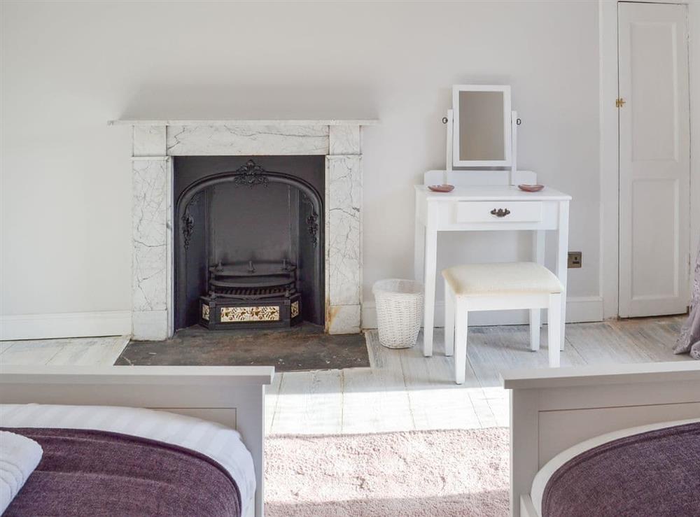 Twin bedroom with original fireplace at West House Farm in Muston, near Filey, North Yorkshire