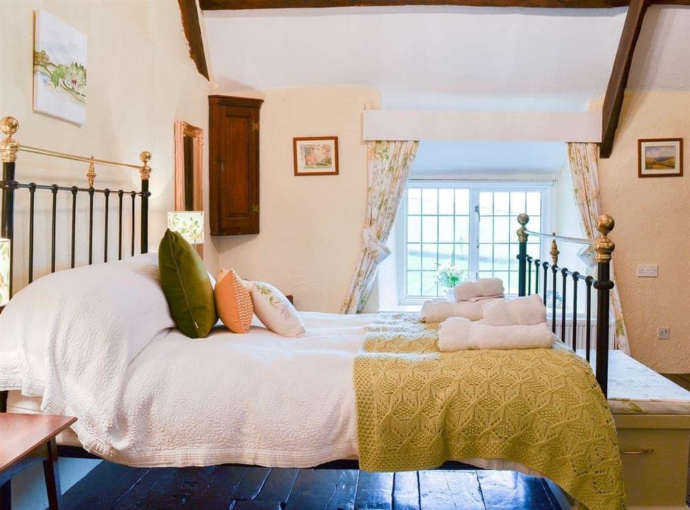Charming double bedroom with antique style bed at West Hurscott Cottage in Hurscott, near Barnstaple, Devon