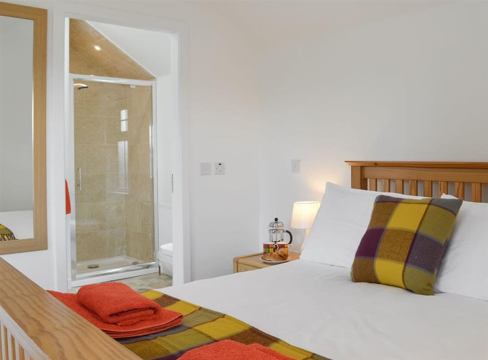Kingsize bed and en-suite with shower cubicle at Wester Laggan Cottage in Dulnain Bridge, near Grantown-on-Spey, Highlands, Morayshire