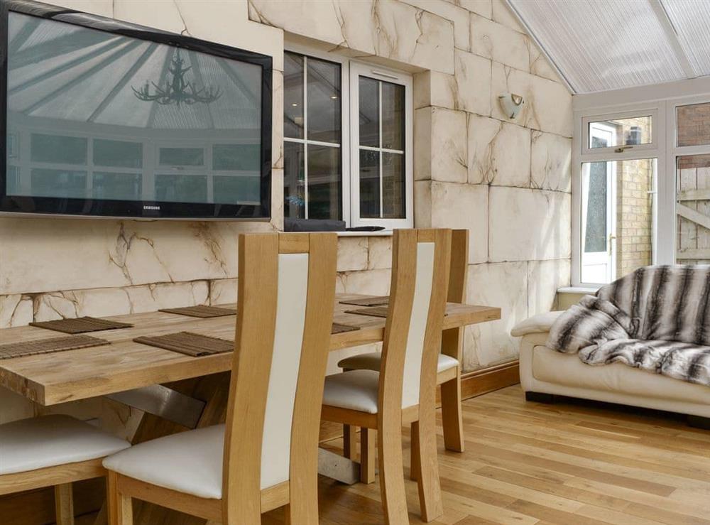 Dining area within the conservatory at Western Fells Cottage in Rowrah, near Frizington, Cumbria