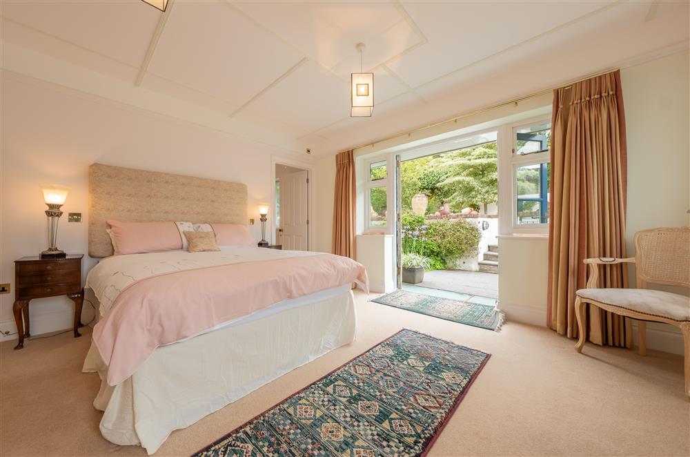 First Floor: Bedroom one with king-size bed, en-suite bathroom and french doors leading out to the garden