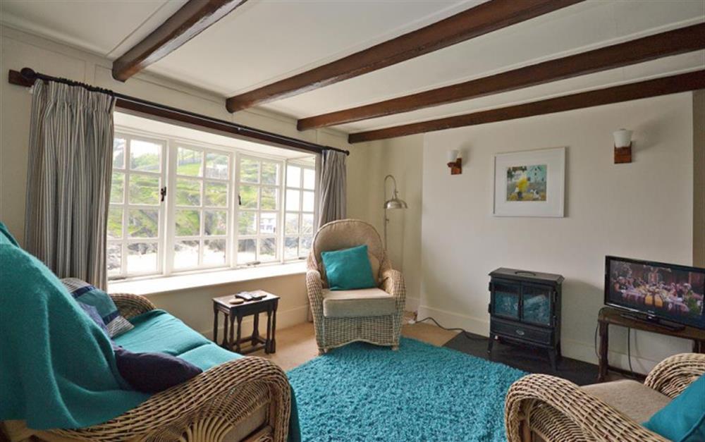 The living room with wood burning effect stove at Westhaven in Polperro