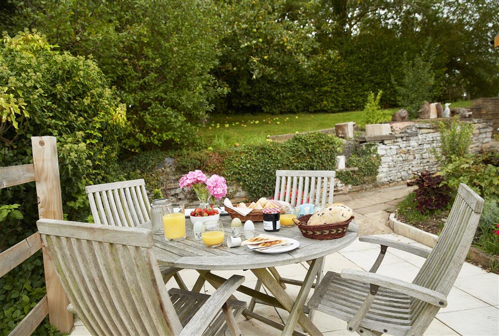 Outdoor dining area with wooden garden furniture at Wharf Cottage, Wootton Wawen
