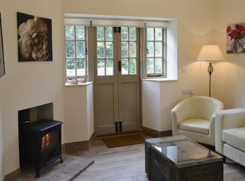 Cosy living room with French doors leading to garden at Whatley Lodge in Winsham, near Chard, Somerset, England