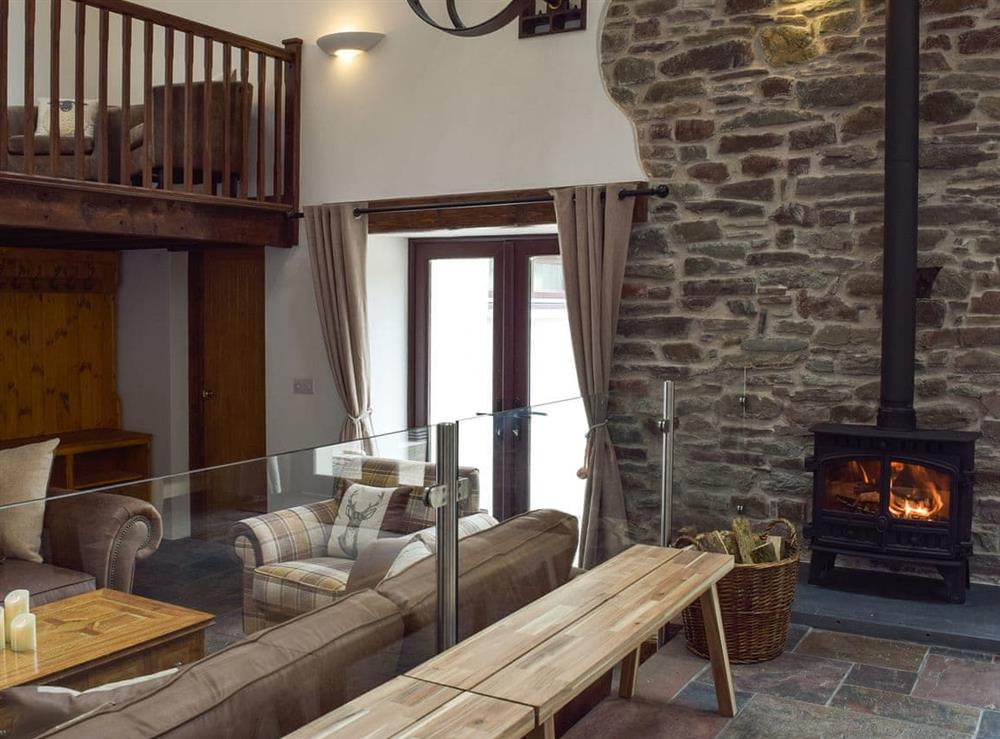 Open plan living space with wood burner at Wheelwright Barn in Ferryside, near Carmarthen, Dyfed